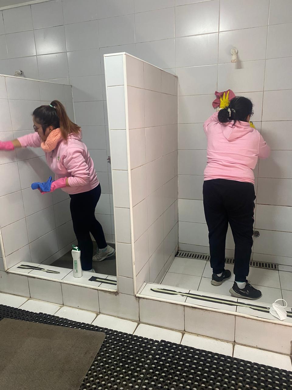 Dos aseadoras de House Cleaning trabajando juntas, con guantes y buzo de la empresa.